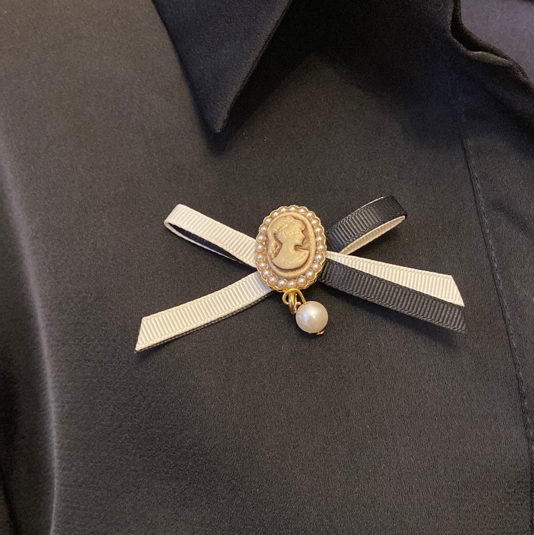 Broche bijoux femme avec flot, buste cané facon ivoire et perle nacrée