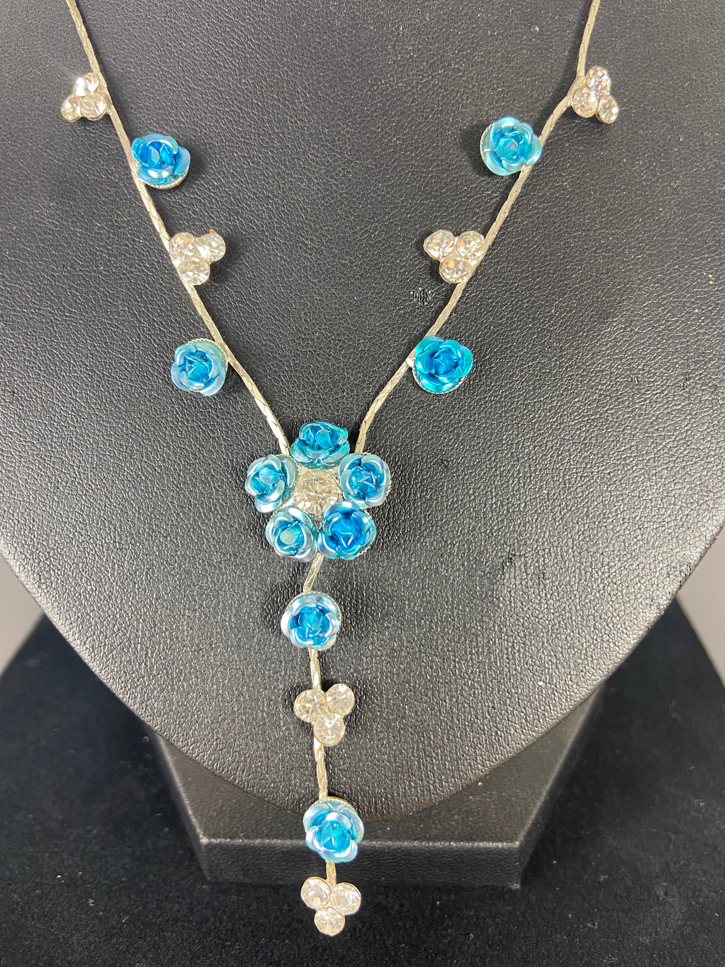 Long collier réglables avec fleurs bleues et brillants sur chaine plate argentée.